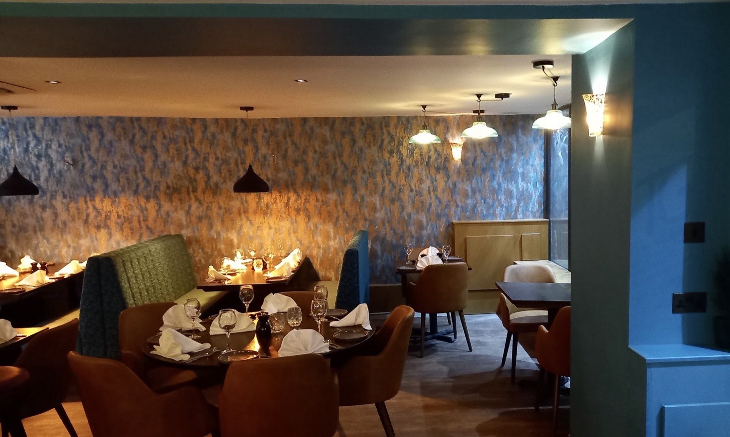 Restaurant dining room with pendant lights and warm wall washers