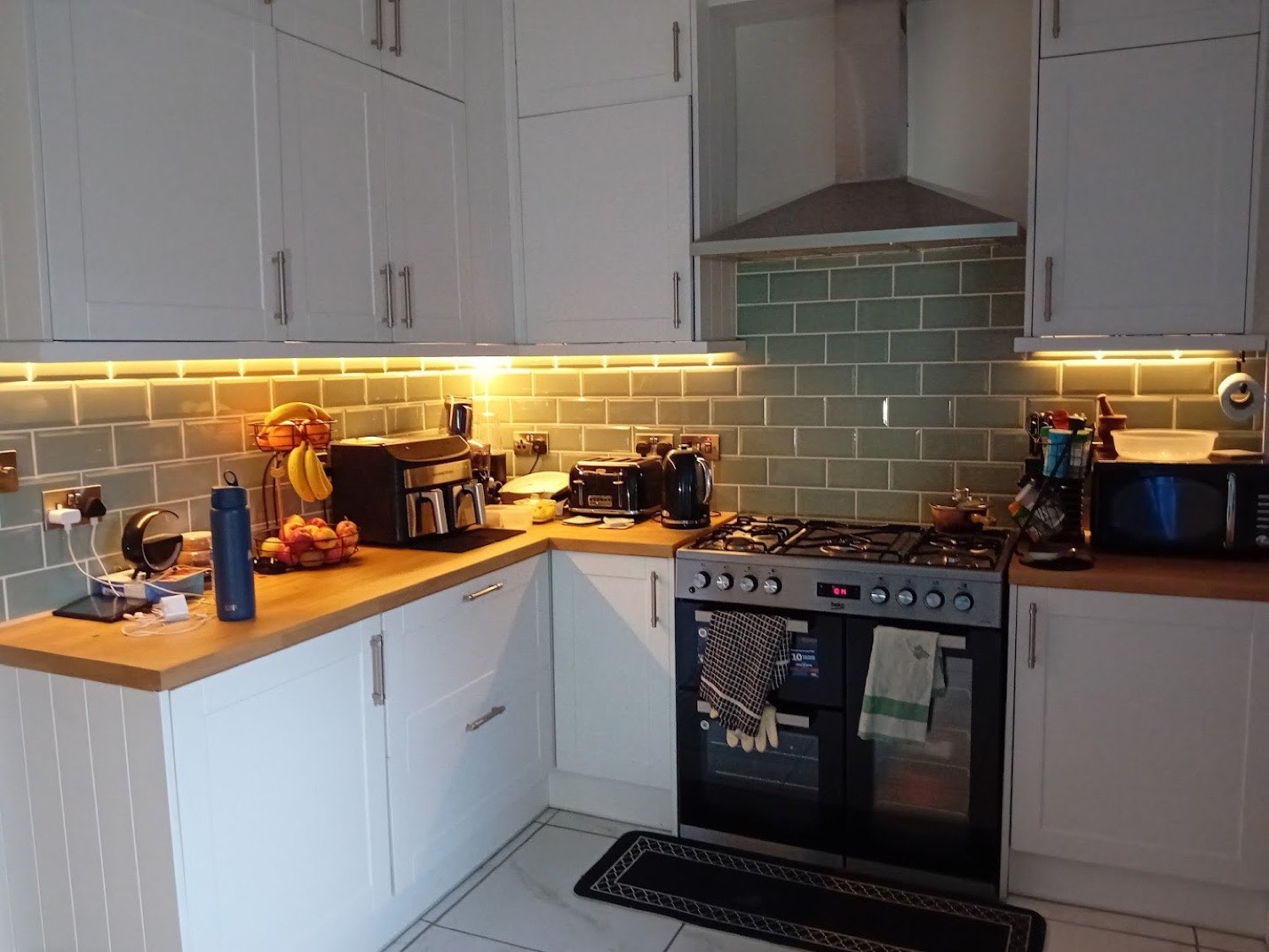 Kitchen with warm under-cabinet strip lighting and sockets