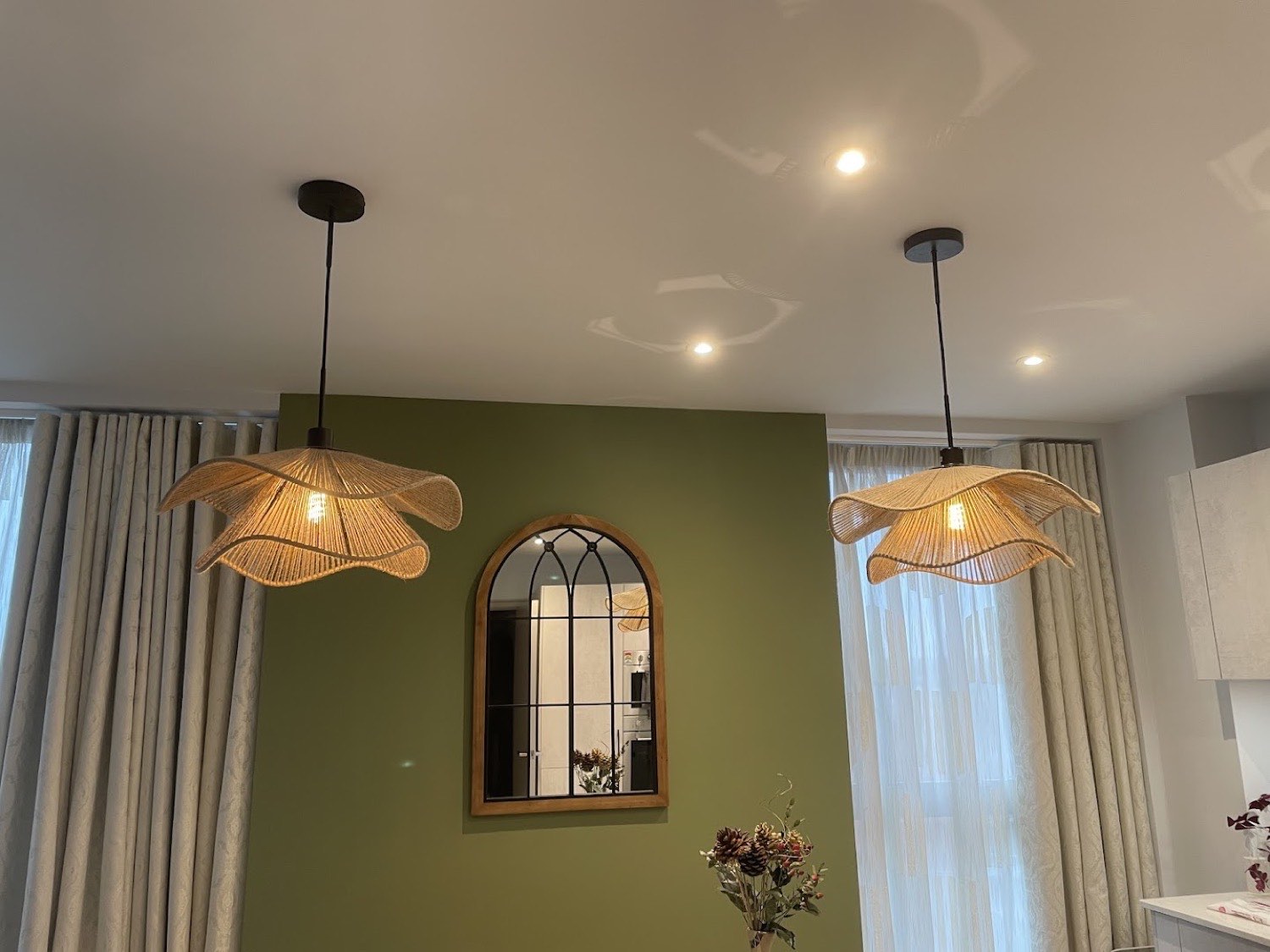Rattan pendants and recessed downlights over a dining table