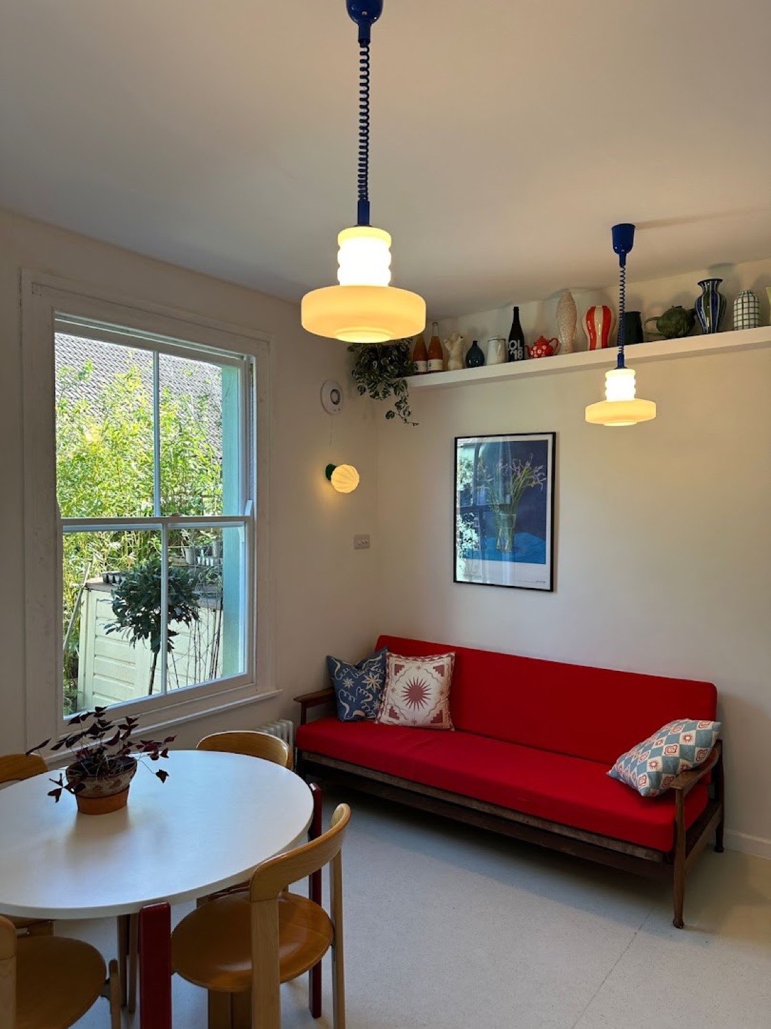 Opaline glass pendants and a small wall reading light in a garden room